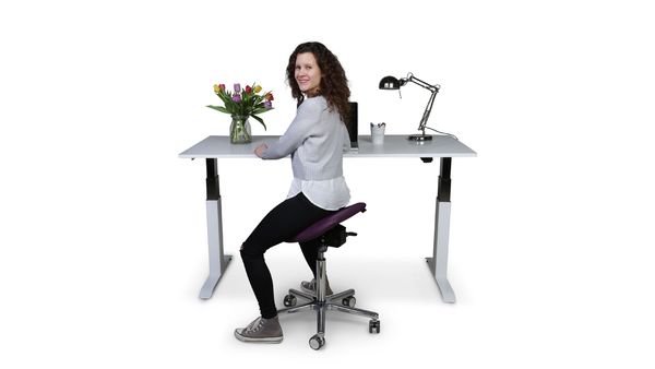 Frau sitzt auf Swippo classic in orchid am höhenverstellbaren Schreibtisch